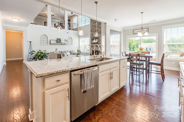a kitchen with granite countertop white cabinets and stainless steel appliances