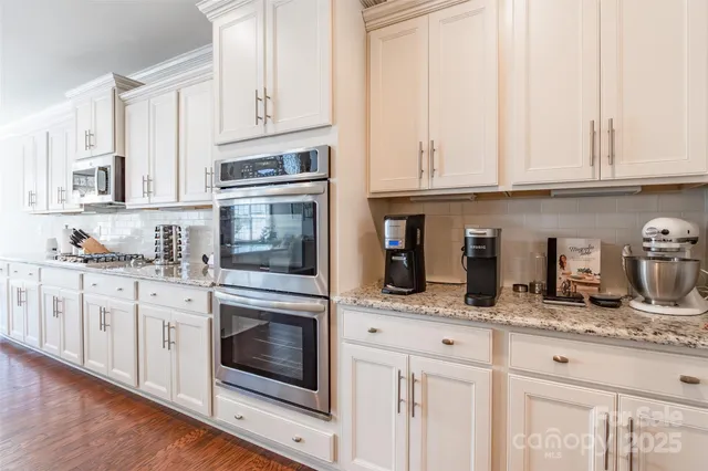 a kitchen with granite countertop a refrigerator sink and cabinets