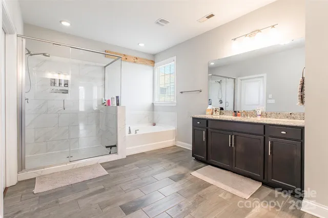 a spacious bathroom with a granite countertop sink and a mirror