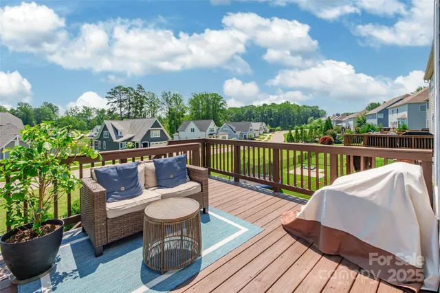 a balcony with wooden floor table and chairs