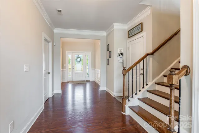 a view of a hallway with wooden floor and staircase