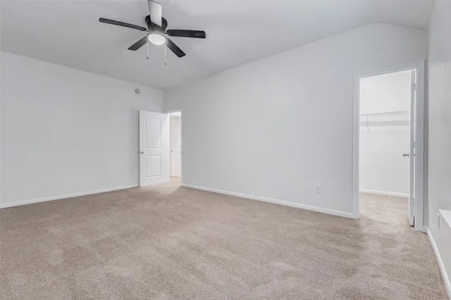 an empty room with chandelier fan