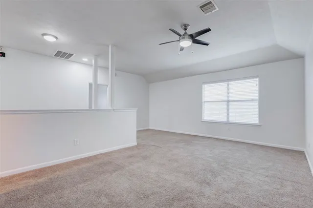 an empty room with fan and windows