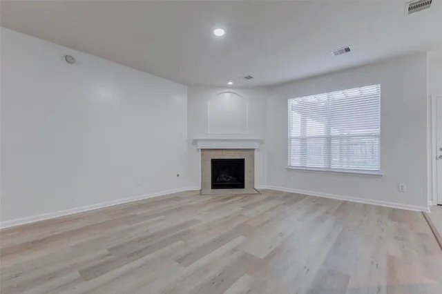 an empty room with windows and fireplace