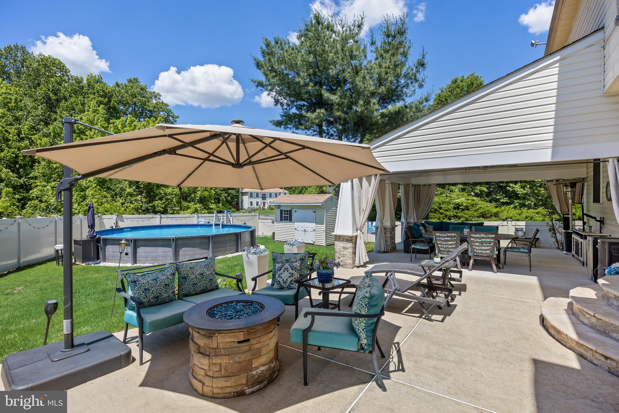 2 Rothbury Drive Lumberton, NJ 08048 - Photo 44 of 54 a backyard of a house with table and chairs under an umbrella