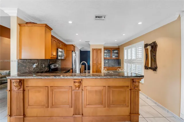 a kitchen with stainless steel appliances granite countertop a stove a sink and a microwave