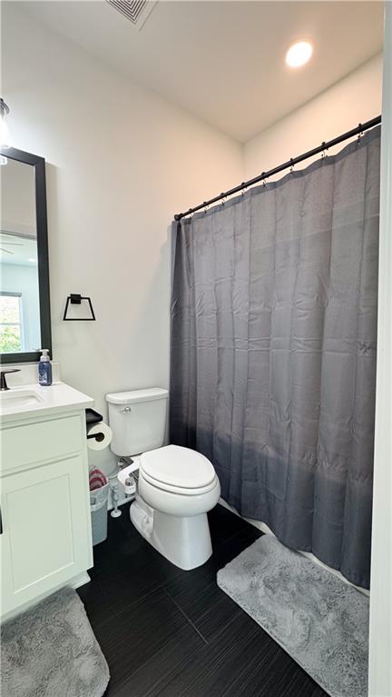 3660 Andover Street Cumming, GA 30028 - Photo 31 of 36 a bathroom with a sink a toilet a mirror and shower curtain