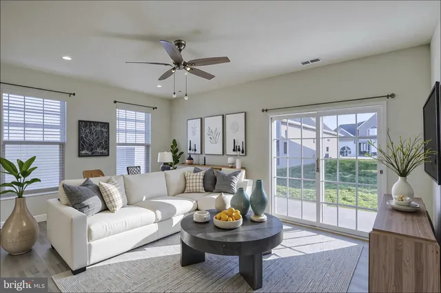 a living room with furniture a window and a potted plant