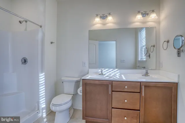 a bathroom with a granite countertop sink toilet and mirror