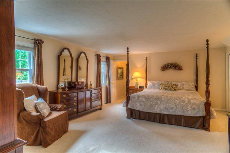 1136 Old Post Road Cotuit, MA 02635 - Photo 14 of 20 a spacious bedroom with a bed and large windows