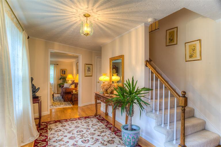 1136 Old Post Road Cotuit, MA 02635 - Photo 4 of 20 a view of a hallway with wooden floor and a chandelier
