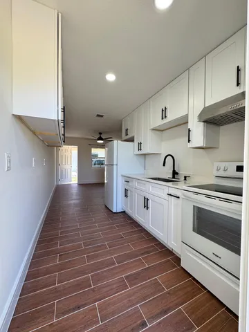 a kitchen with cabinets a sink and appliances
