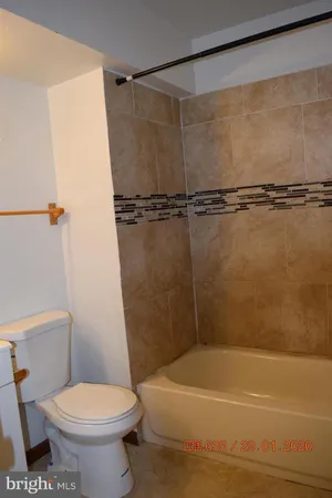 a white toilet sitting next to a bath tub and a shower