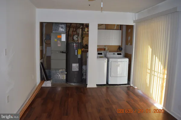 a kitchen with a refrigerator and wooden floor