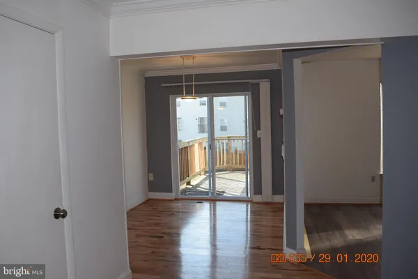 a view of a hallway with wooden floor and a window