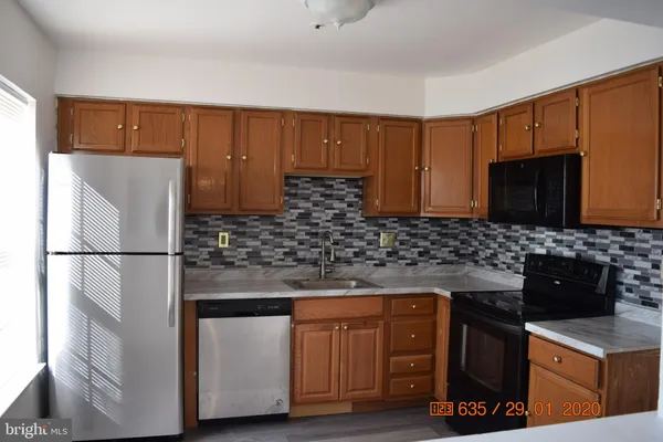 a kitchen with stainless steel appliances granite countertop a refrigerator stove a sink dishwasher and microwave