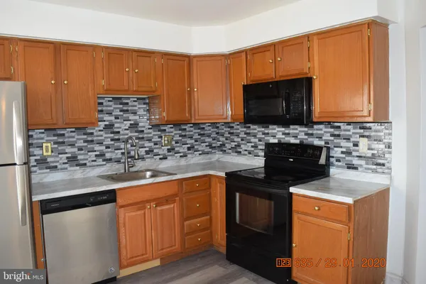 a kitchen with stainless steel appliances granite countertop a sink stove and microwave