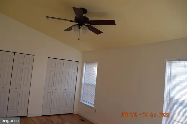 a view of a hallway with a chandelier fan and wooden floor