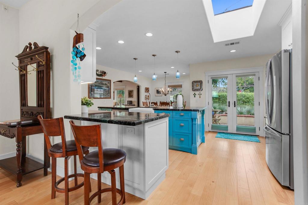 1503 Ridgeway Street Oceanside, CA 92054 - Photo 7 of 56 a kitchen with stainless steel appliances kitchen island granite countertop a table chairs in it and wooden floors