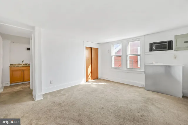 an empty room with windows and closet