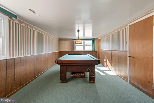 a room with pool table and windows