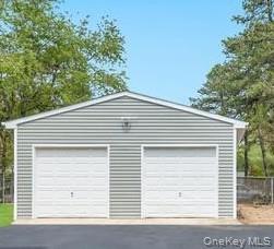491 Hawkins Road Selden, NY 11784 - Photo 42 of 50 Two-car garage featuring horizontal siding, white garage doors