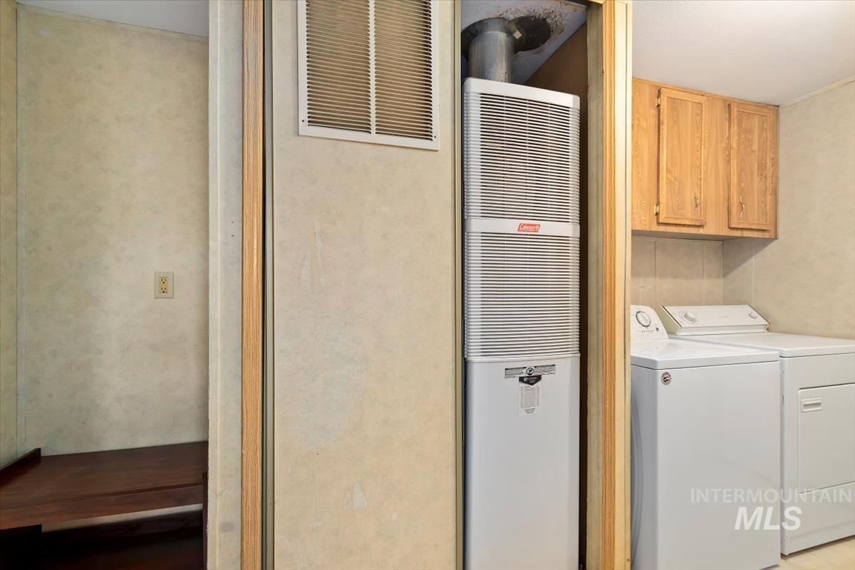 2804 Golden Rod Lane Caldwell, ID 83605 - Photo 21 of 35 Laundry area featuring a heating unit, washer and clothes dryer, and cabinet space