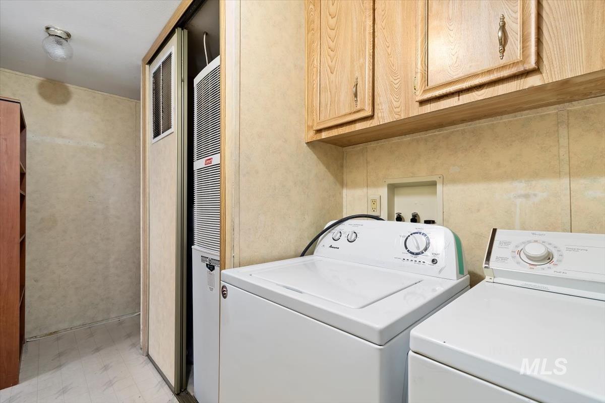 2804 Golden Rod Lane Caldwell, ID 83605 - Photo 22 of 35 Laundry room with light flooring, washing machine and dryer, a heating unit, and cabinet space