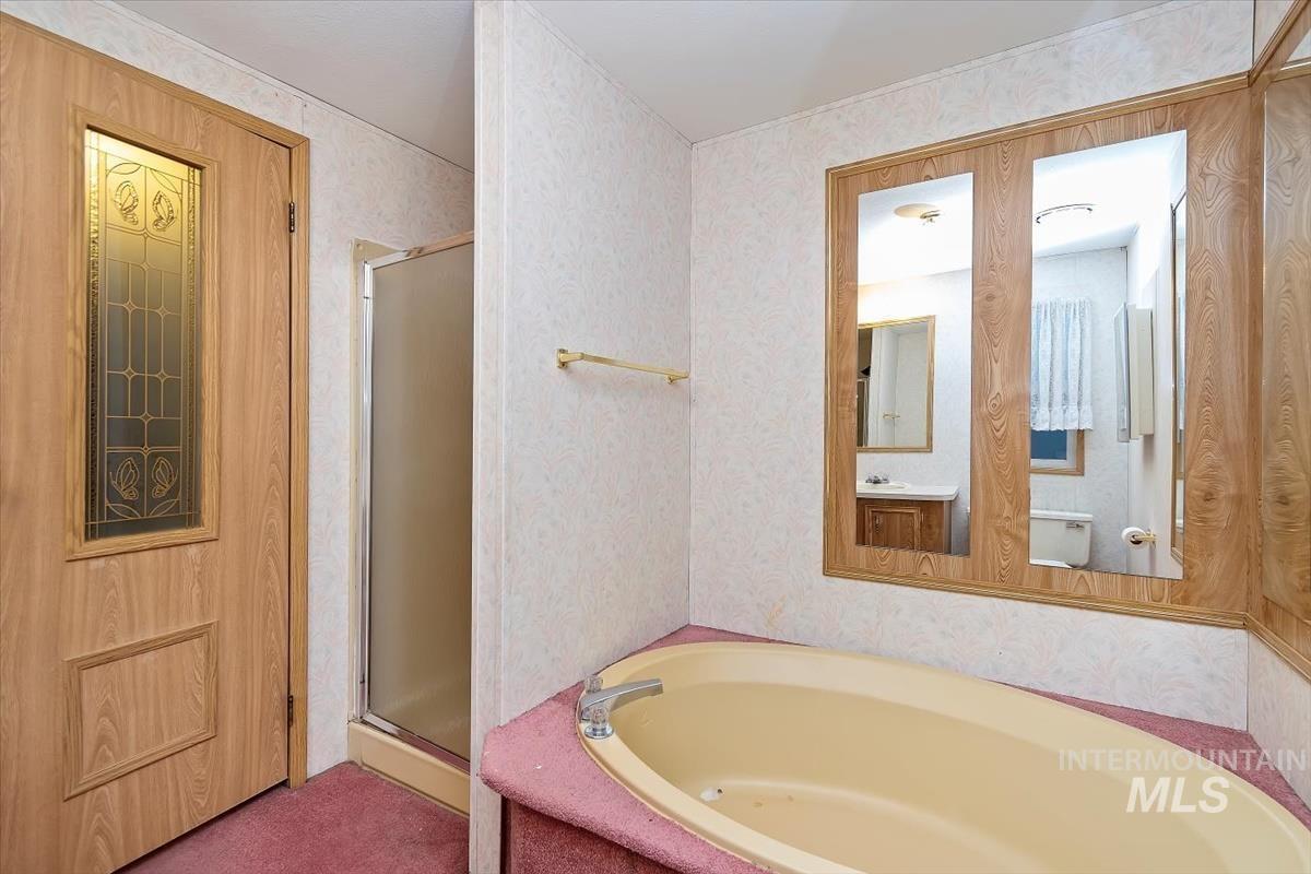 2804 Golden Rod Lane Caldwell, ID 83605 - Photo 10 of 35 Bathroom with a stall shower, a garden tub, and wallpapered walls