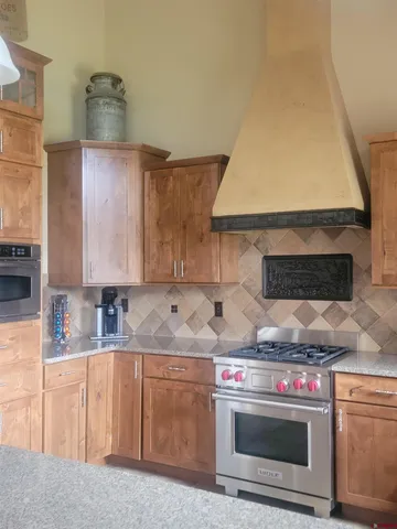 a kitchen with stainless steel appliances granite countertop a sink and a stove