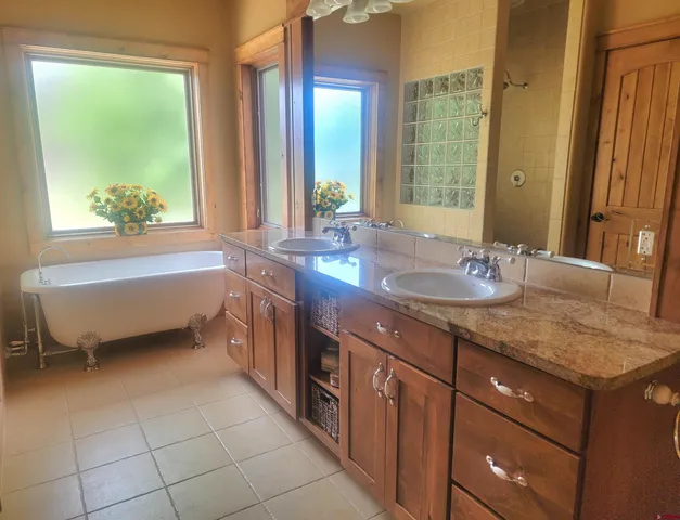 a bathroom with a granite countertop sink and a bathtub