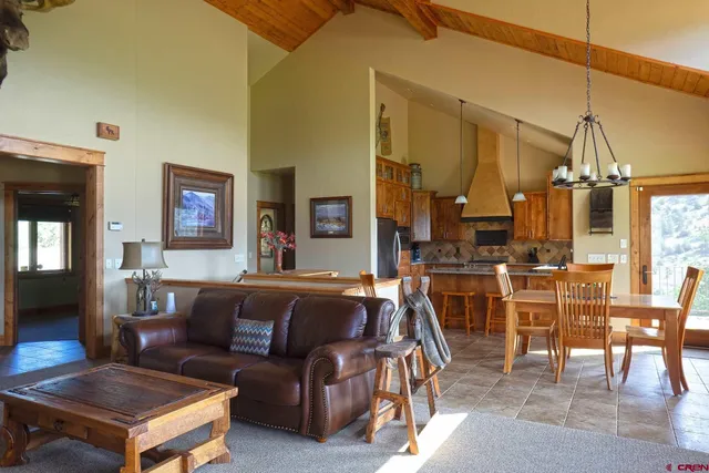 a living room with furniture a dining table and chairs with wooden floor