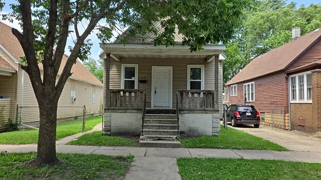 a front view of a house with a garden and trees
