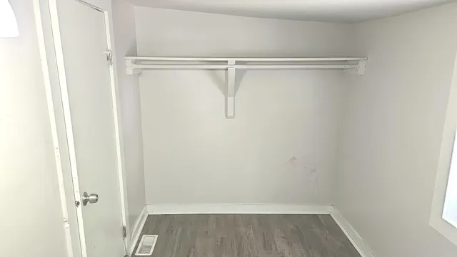 a view of small space with wooden floor and a window