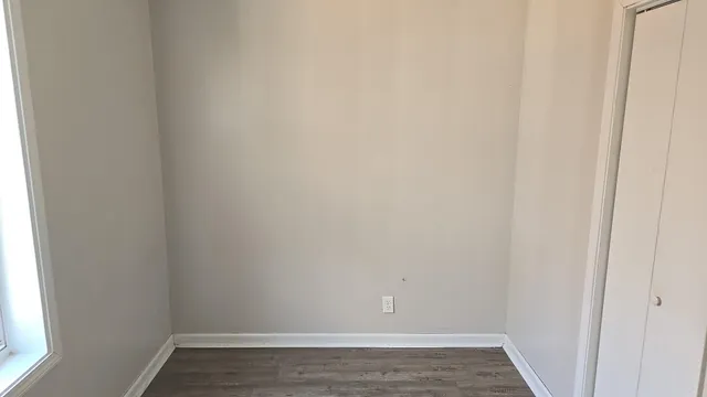 a view of a small space with wooden floor and a window