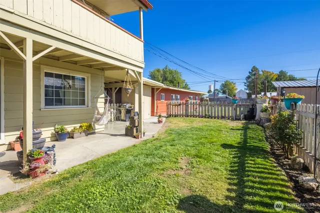 a view of a house with backyard and sitting area