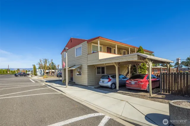 a front view of a building with parked cars