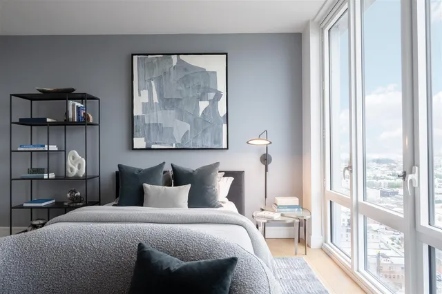 a bedroom with a bed and a painting on the wall