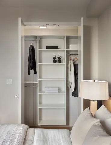 a view of walk in closet with clothes and shoes