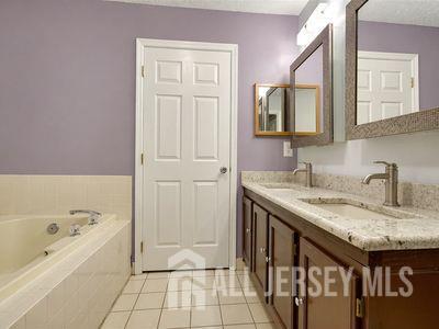31 Edinburgh Court Edison, NJ 08820 - Photo 20 of 25 a bathroom with a granite countertop sink a mirror and bathtub