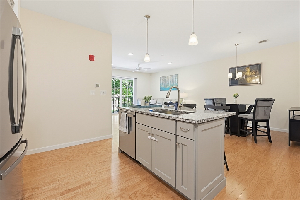 200 Revere Street, Unit 4209 Canton, MA 02021 - Photo 10 of 35 a kitchen with stainless steel appliances granite countertop a sink and a refrigerator