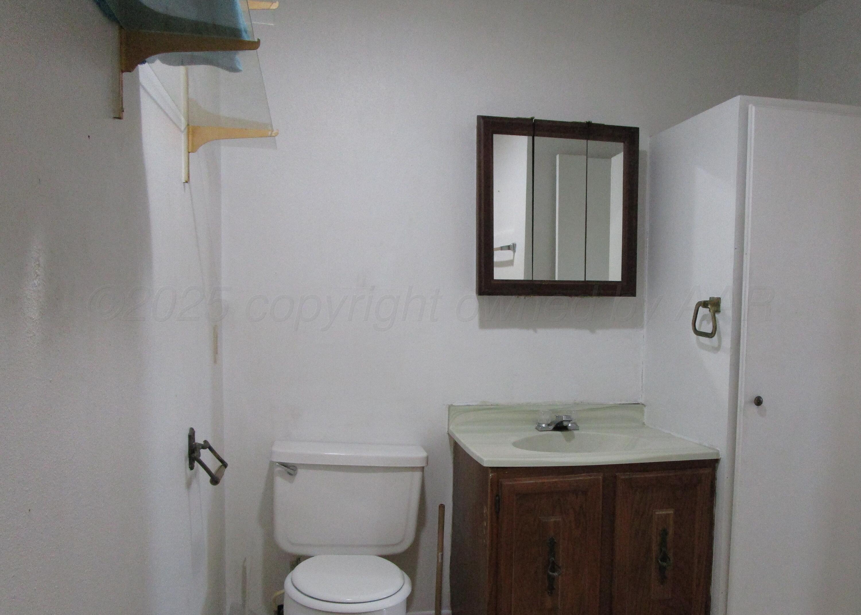 200 West 7th Street Borger, TX 79007 - Photo 6 of 8 a bathroom with a toilet sink and mirror