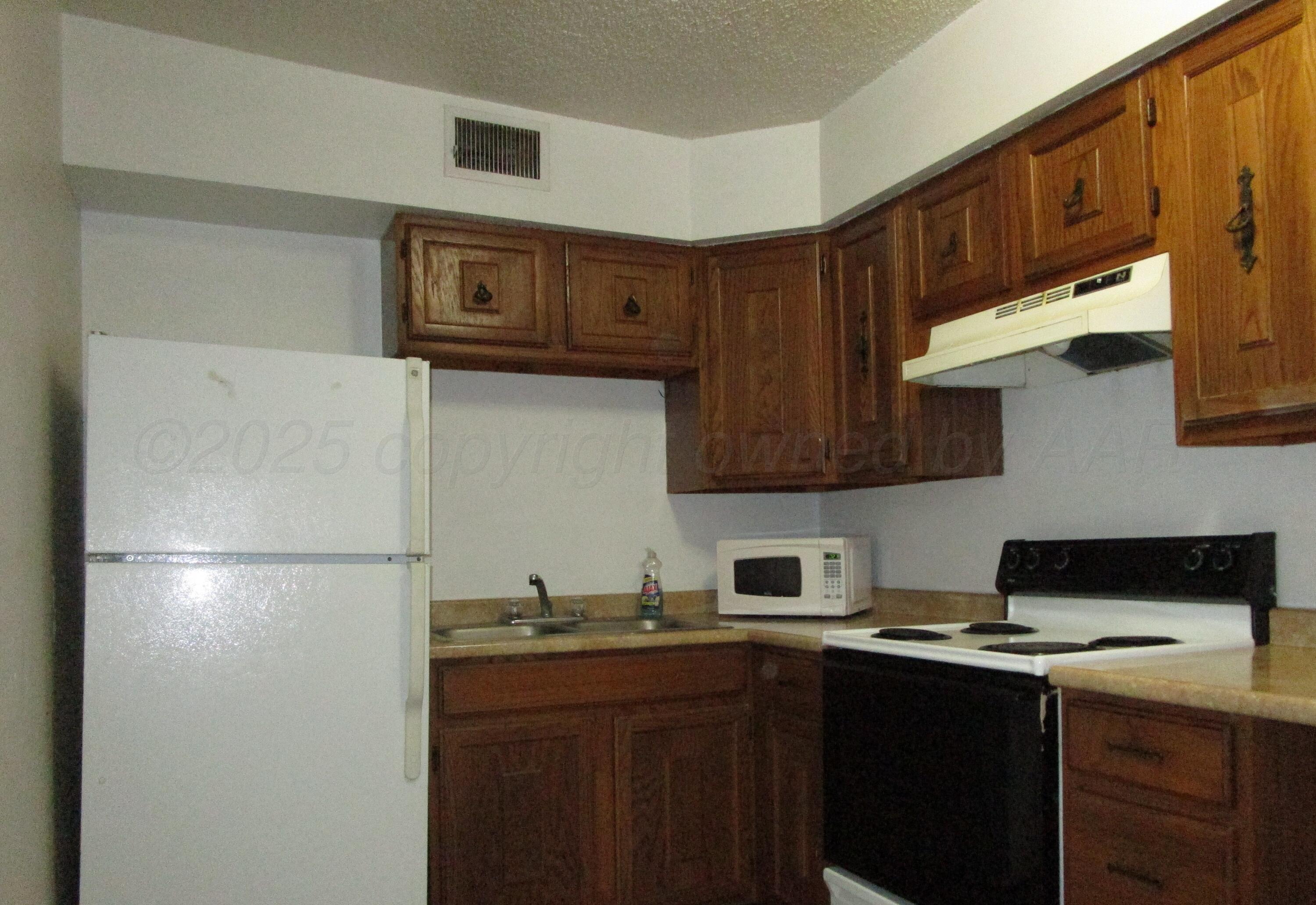 200 West 7th Street Borger, TX 79007 - Photo 7 of 8 a kitchen with stainless steel appliances granite countertop a refrigerator a sink and a stove