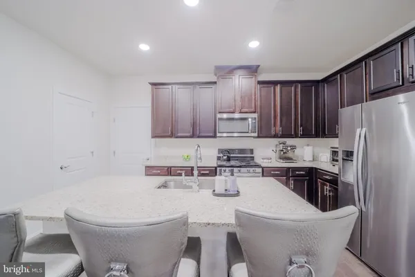a kitchen with a dining table chairs sink and cabinets