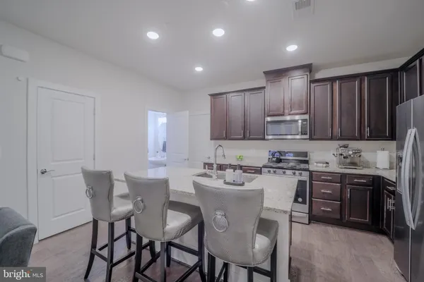 a view of kitchen with refrigerator stove dining table and chairs