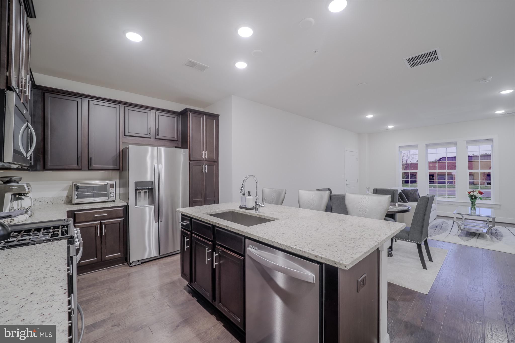 20355 Century Boulevard, Unit 177L Germantown, MD 20874 - Photo 15 of 69 a view of kitchen with refrigerator stove dining table and chairs