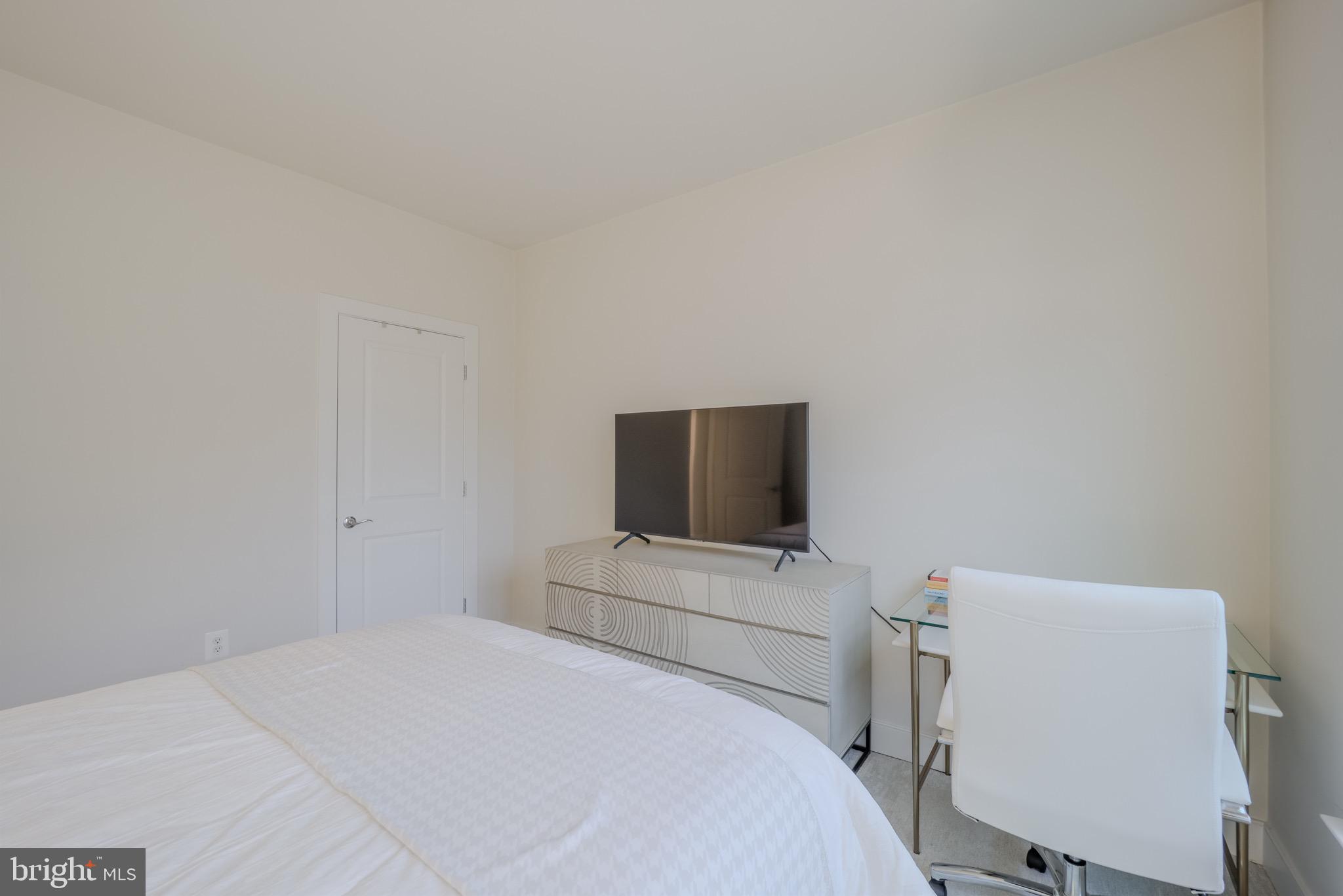 20355 Century Boulevard, Unit 177L Germantown, MD 20874 - Photo 27 of 69 a bedroom with a bed tv and a chair