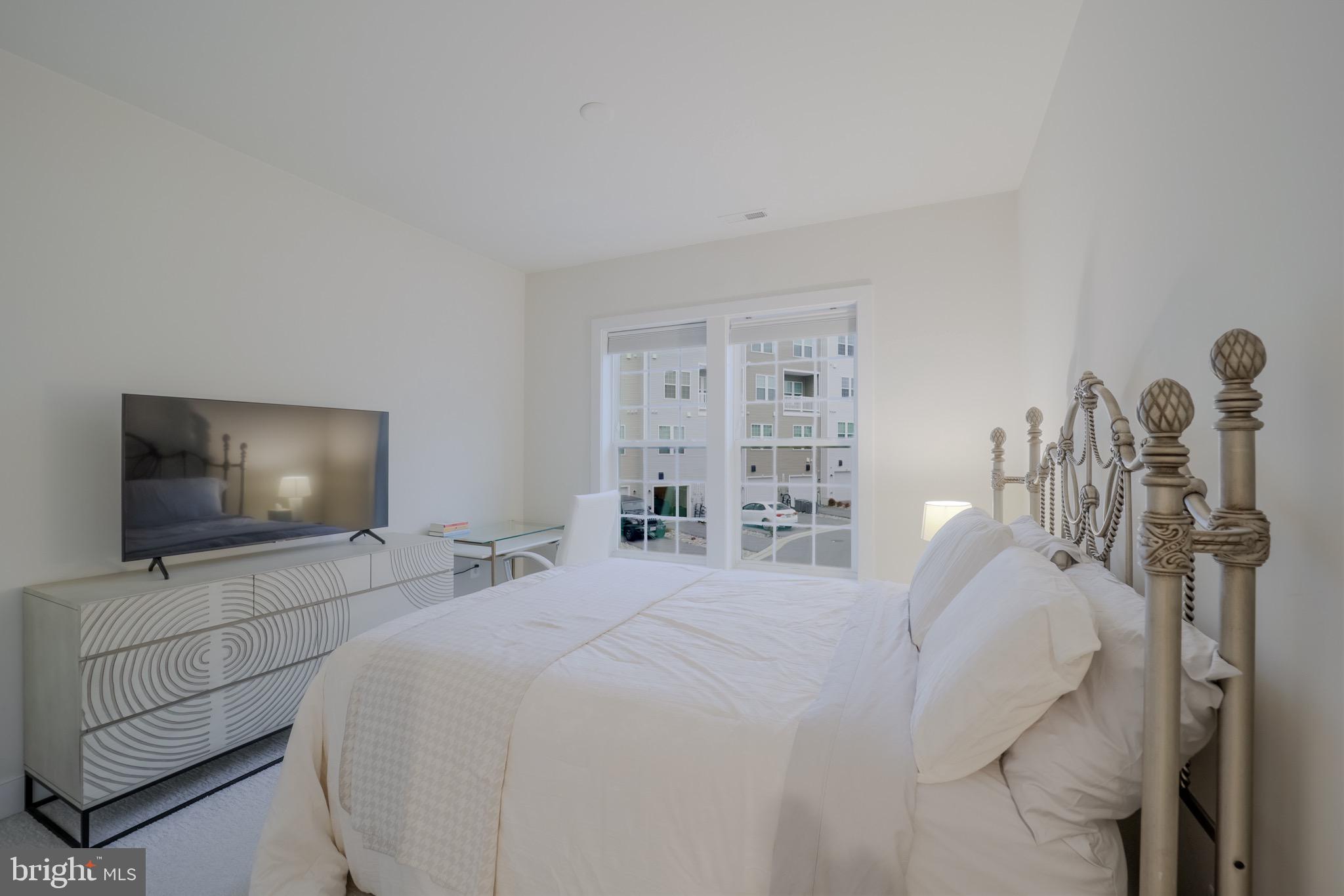 20355 Century Boulevard, Unit 177L Germantown, MD 20874 - Photo 28 of 69 a bedroom with a bed and flat screen tv