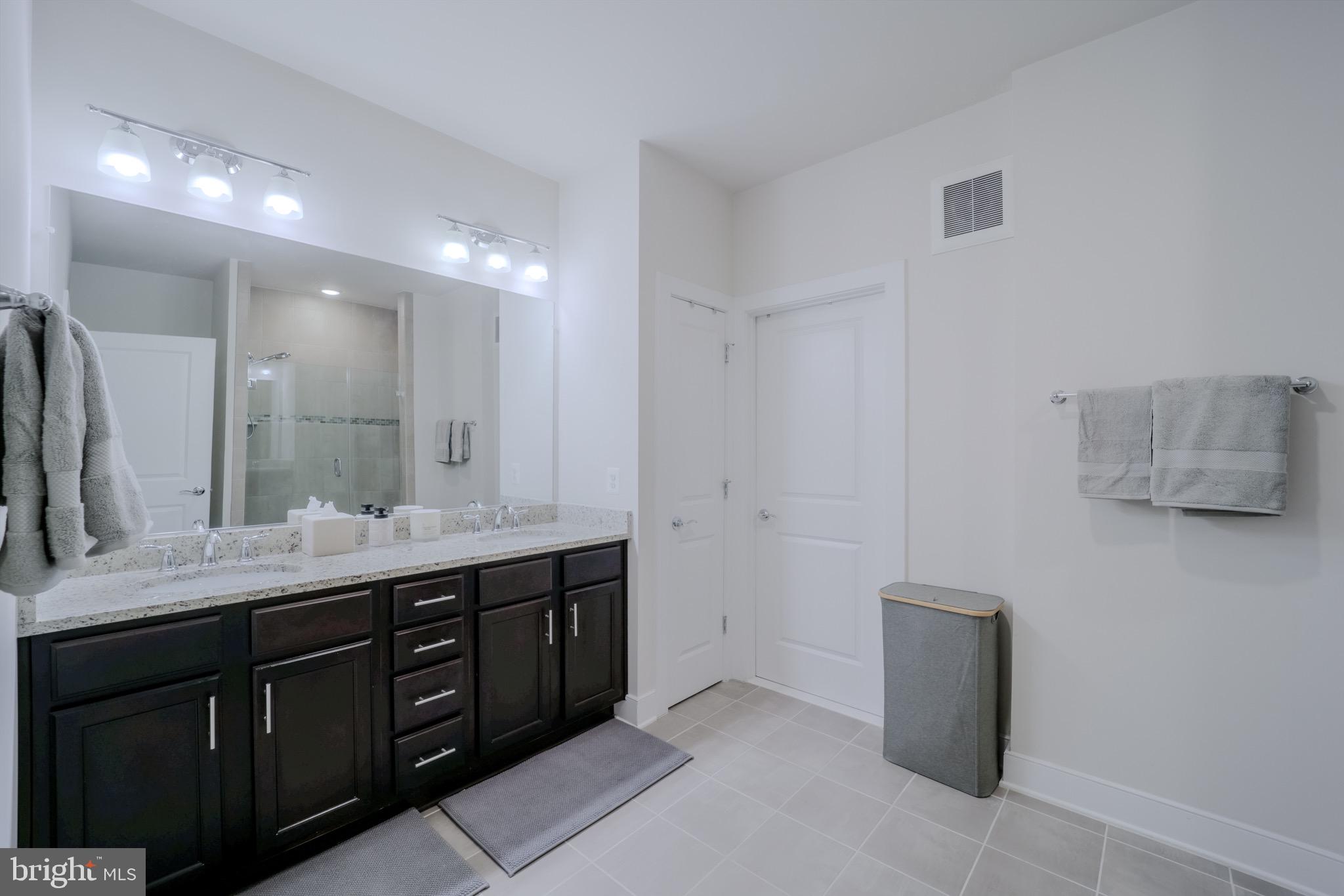 20355 Century Boulevard, Unit 177L Germantown, MD 20874 - Photo 31 of 69 a bathroom with a double vanity sink and mirror