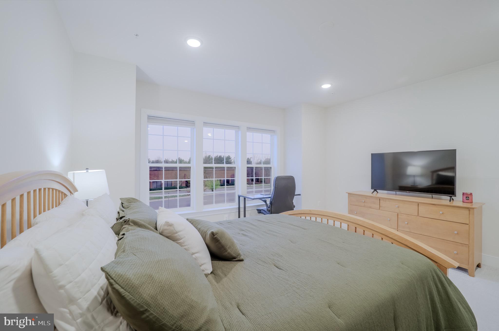 20355 Century Boulevard, Unit 177L Germantown, MD 20874 - Photo 34 of 69 a bedroom with a bed and a flat screen tv